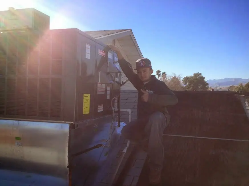 HVAC technician performing AC Tune-Up on a rooftop unit in Houma